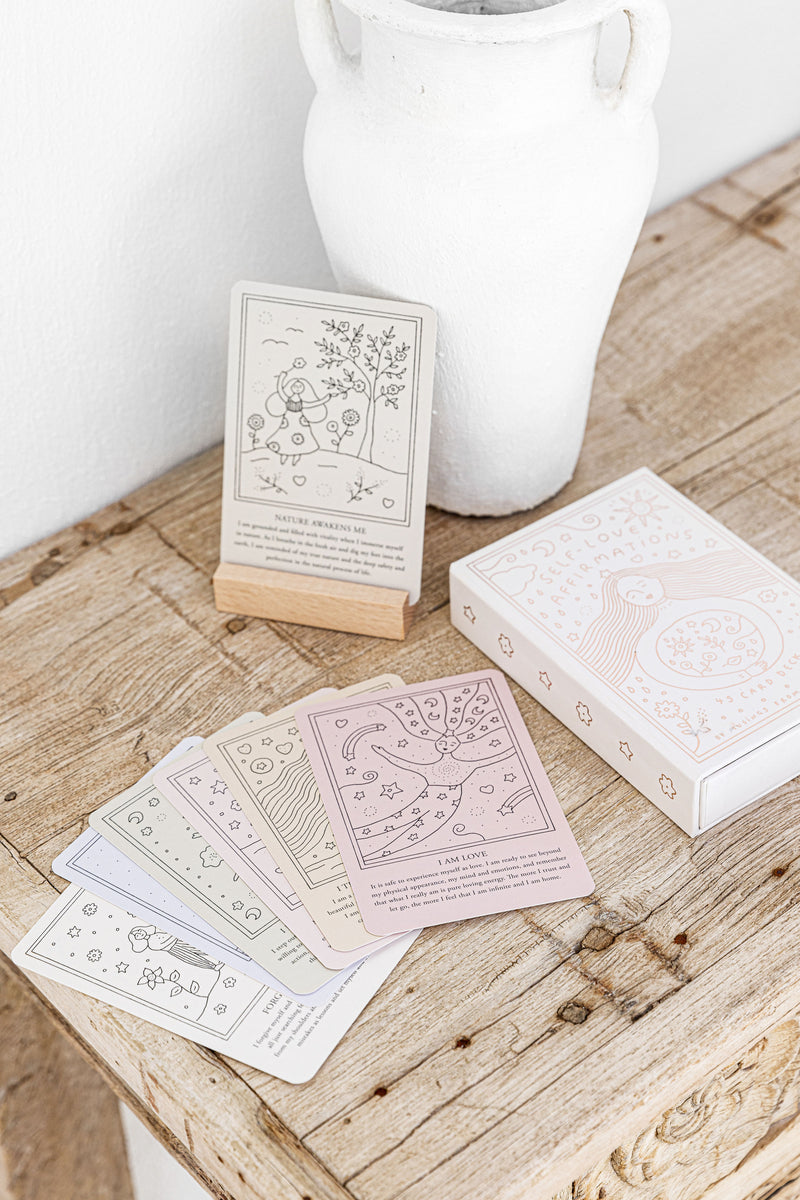Pack of affirmation cards on wooden table.