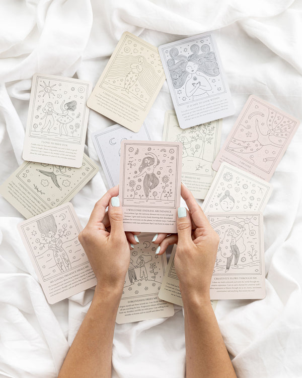 Close up of hands holding affirmation cards.