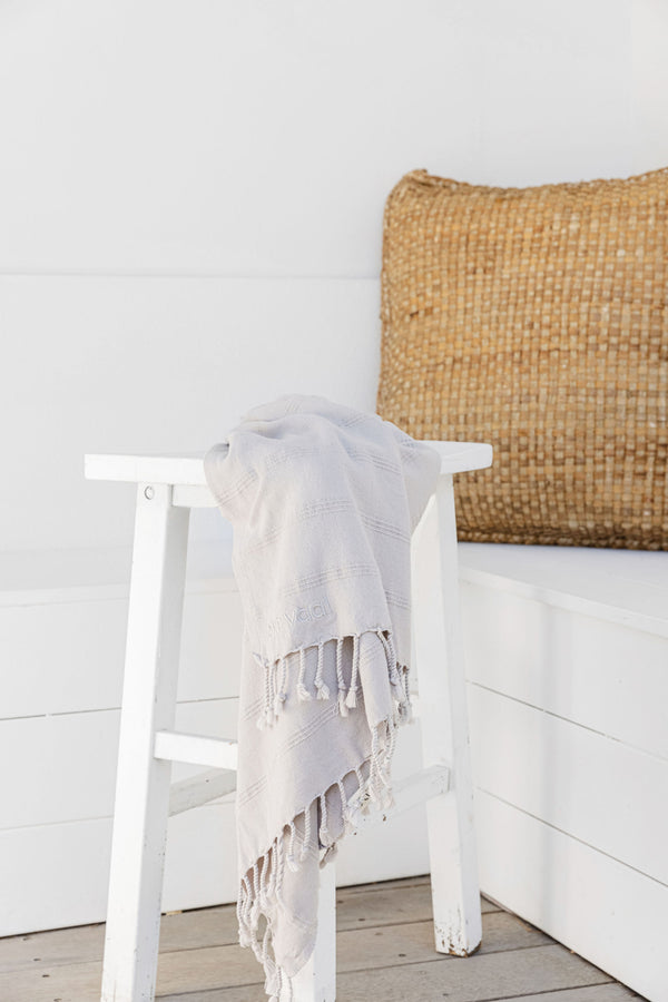 Turkish towel draped on white stool.