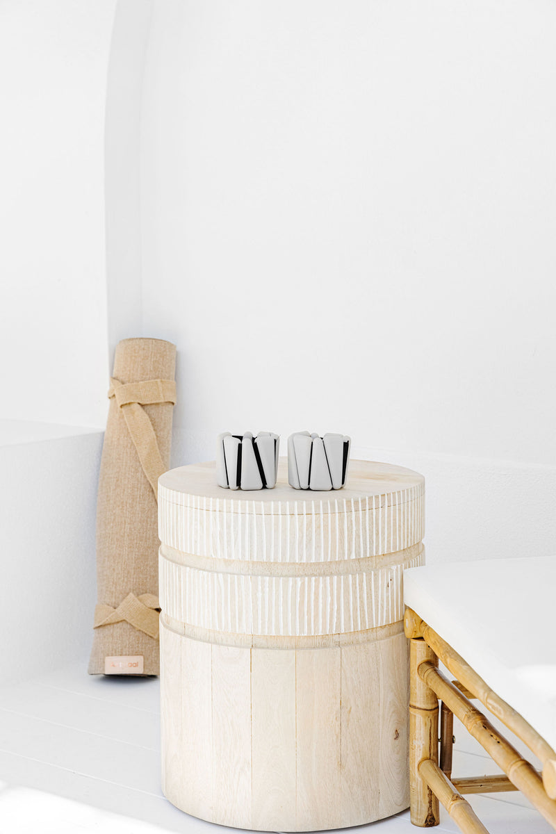 Silicone wrist and ankle weights sitting on wooden table.