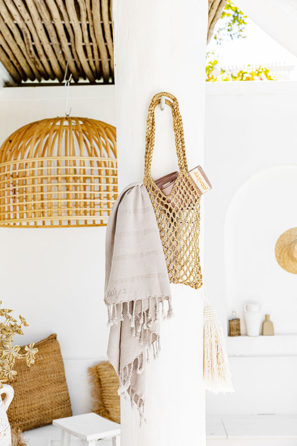 Jute bag hanging from a hook with a Turkish towel.