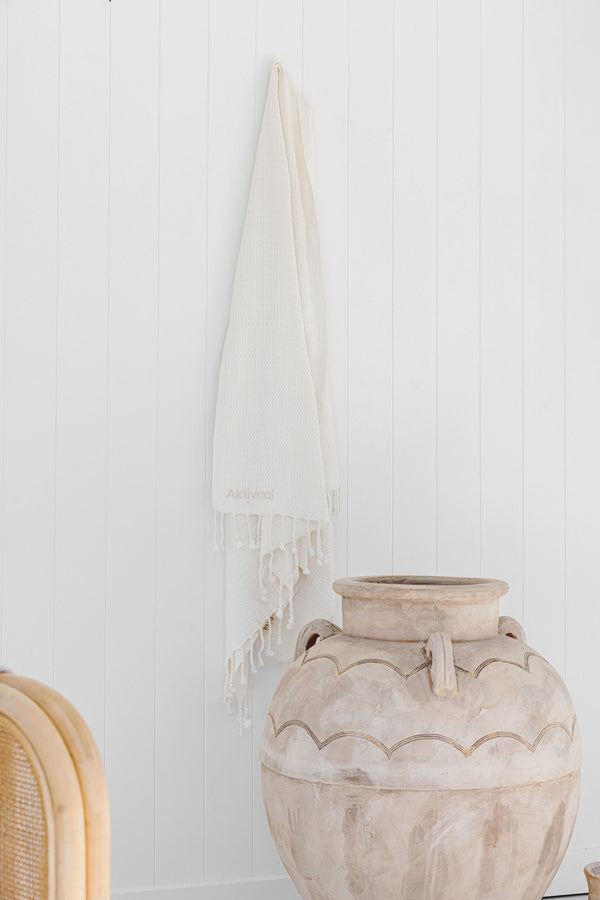 Oat Turkish towel hanging from hook.